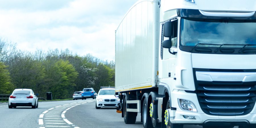 A large HGV vehicle traveling along one of the main road routes of the United Kingdom, on a summer's day. Taking goods to and from their suppliers and customers.