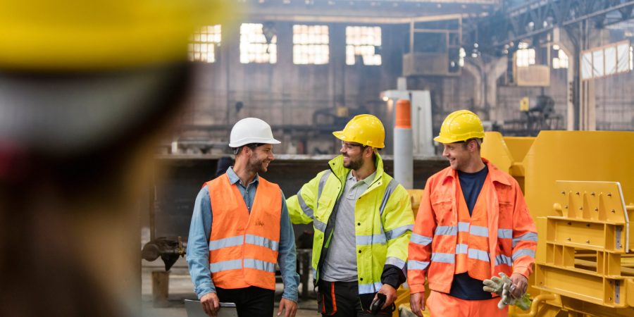 Steel workers walking and talking in factory